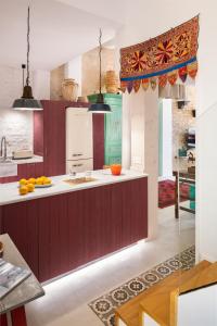 una cocina con armarios rojos y encimeras blancas en CSE San Bernardo, en Sevilla