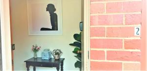 a picture of a woman sitting on a table next to a brick wall at Kennington Units Family in Kennington