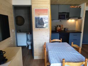 a small room with a table and a kitchen at Appartement confort et style en pied de piste in Bolquere Pyrenees 2000