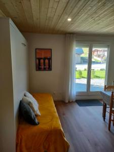 1 dormitorio con 1 cama en una habitación con ventana en Appartement confort et style en pied de piste en Bolquere Pyrenees 2000