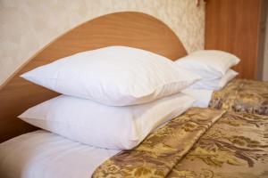 a pile of pillows on a bed in a room at Bukovyna Hotel in Chernivtsi