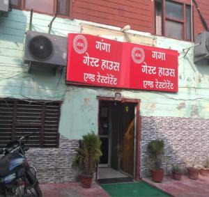 a building with red signs on the side of it at Ganga Guest House By WB Inn in Agra