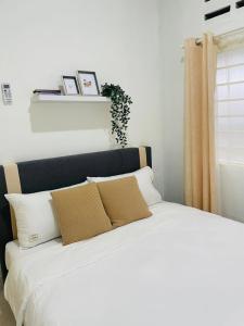 białe łóżko z dwoma poduszkami w obiekcie Chenang's Guest House by The Nordic House w mieście Pantai Cenang