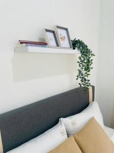 a shelf above a bed with books and a plant at Chenang's Guest House by The Nordic House in Pantai Cenang