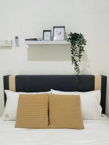 a bed with two pillows and a plant on it at Chenang's Guest House by The Nordic House in Pantai Cenang