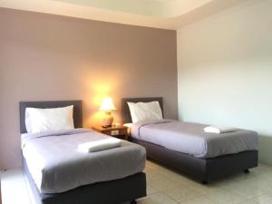 um quarto de hotel com duas camas e um candeeiro em Kamalaburi Guesthouse em Kamala Beach