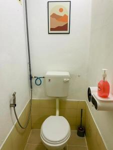 a small bathroom with a toilet and a sink at Chenang's Guest House by The Nordic House in Pantai Cenang