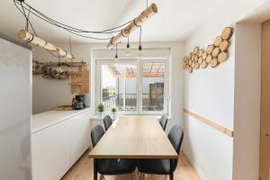 Apartments Rok في ليوبليانا: غرفة طعام مع طاولة وكراسي خشبية