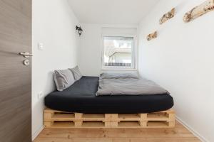 łóżko na drewnianej platformie w pokoju w obiekcie Apartments Rok w Lublanie