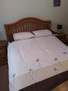 1 cama con sábanas blancas y 2 almohadas en Rose Bungalow In Carlton Colville en Pakefield