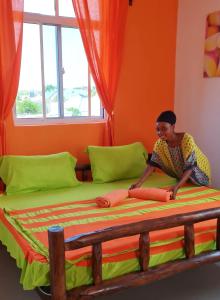a woman sitting on a bed in a room at Frangipani House Nungwi Zanzibar in Nungwi +59 photos