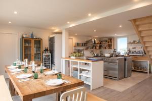 a kitchen with a long wooden table in a room at Hôtel Sport & Spa, Ile d'Ouessant, The Originals Collection in Ouessant