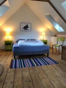 1 dormitorio con 1 cama, 2 lámparas y 1 alfombra en La maison du pêcheur, en Saint-Quay-Portrieux