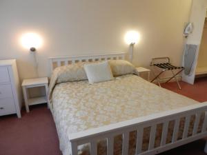 um quarto com uma cama com duas mesas e dois candeeiros em Schoolhouse Restaurant and Hotel em Swindon