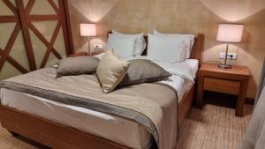 a bedroom with a bed with pillows and two lamps at Apartman B428 Vucko private host in Jahorina