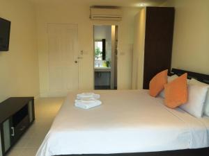 a bedroom with a large white bed with towels on it at Glitter House Phuket in Kata Beach