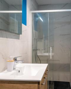 La salle de bains blanche est pourvue d'un lavabo et d'une douche. dans l'établissement Esprit cosy - Welc'Home, à Limoges