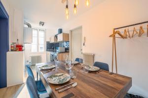 een eetkamer met een houten tafel en blauwe stoelen bij Esprit cosy - Welc'Home in Limoges