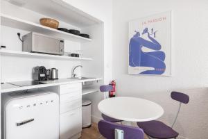 カスカイスにあるEquador Superior Suites by Olala Homesのキッチン(白いテーブル、紫色の椅子付)