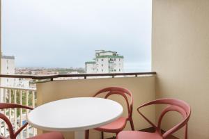 a table and chairs on a balcony with a white table and chairs at Equador Superior Suites by Olala Homes in Cascais
