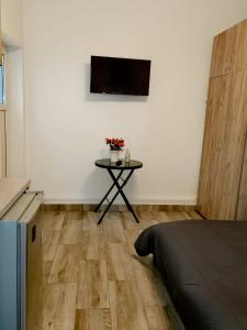 a room with a table with flowers and a tv at Stay In Tmisoara in Timişoara