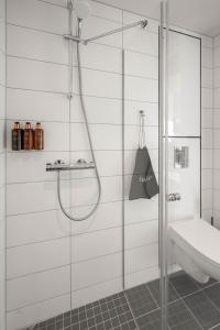 bagno con doccia e porta in vetro di Clarion Collection Hotel Arcticus a Harstad