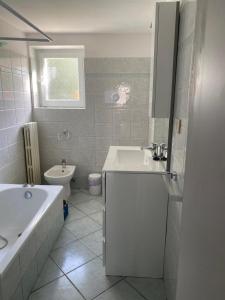 ein Badezimmer mit einer Badewanne, einem Waschbecken und einem WC in der Unterkunft Bonsai - Bed & Breakfast in Pesaro