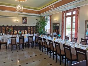 une salle à manger avec des tables et des chaises ainsi qu'un lustre dans l'établissement Pałac Koronny Noclegi & Wypoczynek, à Wodzisław