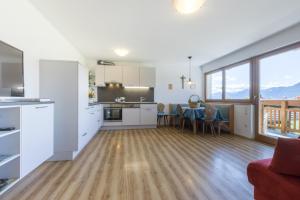 een keuken en een woonkamer met een tafel en stoelen bij Stimpflhof in Aldino