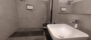 Baño blanco con lavabo y espejo en VIVIDEARTH Resorts Bandipur en Bandipūr