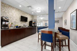 a lobby with a bar with blue chairs at Comfort Inn & Suites St Louis-Hazelwood in Hazelwood