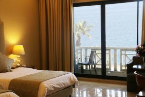 a hotel room with a bed and a view of the ocean at Bayview Hotel Beirut in Beirut