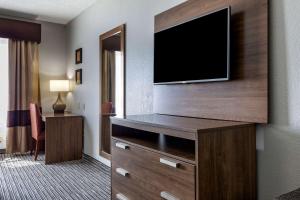 a hotel room with a flat screen tv on a wall at Quality Inn & Suites I-35 E/Walnut Hill in Dallas