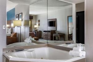 a large bathroom with a tub and a large mirror at Quality Inn & Suites I-35 E/Walnut Hill in Dallas