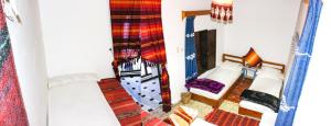 ein kleines Zimmer mit 2 Betten und einer Lampe in der Unterkunft Cordoba Pension in Chefchaouen
