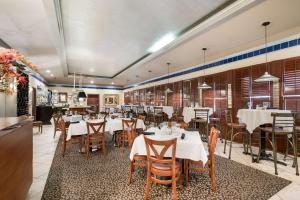 un comedor con mesas y sillas blancas en Quality Inn & Suites Lufkin en Lufkin