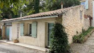 uma velha casa de pedra com uma árvore em frente em Joli mazet à Nîmes idéalement situé entre la garrigue et la ville em Nîmes