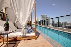 a balcony with a swimming pool on top of a building at Vibe Hotel Sydney Darling Harbour in Sydney
