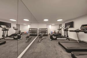a gym with treadmills and ellipticals and mirrors at Vibe Hotel Sydney Darling Harbour in Sydney
