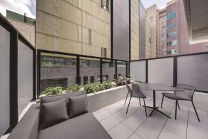 a balcony with a table and chairs on a building at Vibe Hotel Sydney Darling Harbour in Sydney