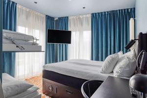 una camera da letto con un letto con tende blu e una scrivania di Best Western and Hotel Linkoping a Linköping