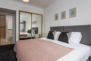 a bedroom with a large bed and a mirror at No27 The Barclay - Donnini Apartments in Kilmarnock