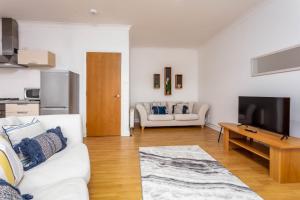 a living room with a white couch and a table at No27 The Barclay - Donnini Apartments in Kilmarnock