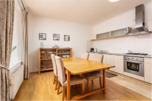 a kitchen and dining room with a wooden table and chairs at No27 The Barclay - Donnini Apartments in Kilmarnock