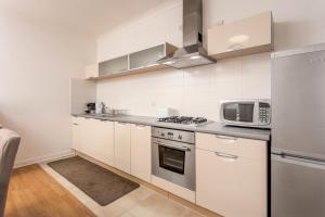 a kitchen with white cabinets and a microwave at No27 The Barclay - Donnini Apartments in Kilmarnock