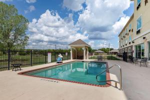 a swimming pool in a courtyard next to a building at Comfort Inn & Suites Gatesville near Fort Cavazos in Gatesville