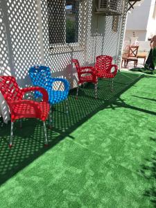 a group of red and blue chairs on a patio at Morning Star Guesthouse in Sharm El Sheikh