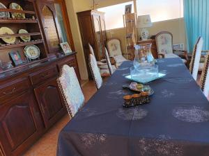 ein Esszimmer mit einem blauen Tisch und einer Vase darauf in der Unterkunft Chambres d'hôtes au pied des Pyrénées 
