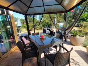 einen Tisch und Stühle auf einer Terrasse mit Sonnenschirm in der Unterkunft Chambres d'hôtes au pied des Pyrénées 