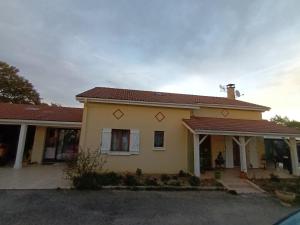 ein gelbes Haus mit rotem Dach in der Unterkunft Chambres d'hôtes au pied des Pyrénées 
